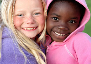как дружат разные культуры в США - дети с разным цветом кожи - девочка-блондинка со светлыми волосами веснушками и голубыми глазами, чернокожая маленькая девочка улыбается