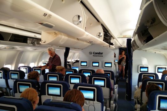 места в селедине салона - очереди с пассажирами возле туалета на борту самолете во время полета
