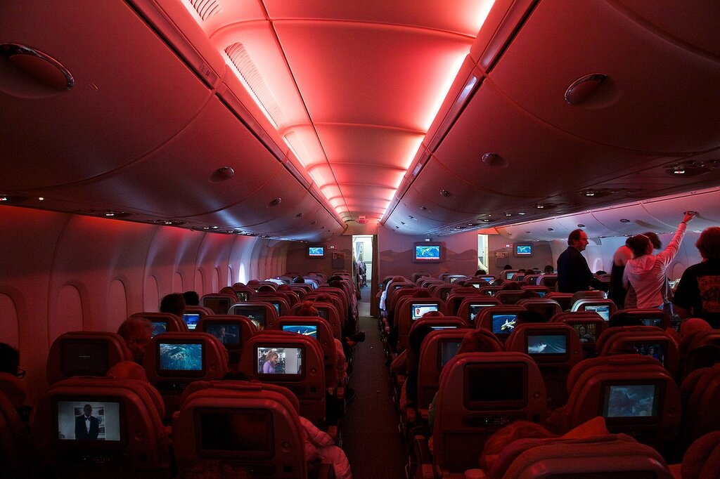 первые места в самолете следующие за бизнес классом напротив экрана - как выглядит салон авиалайнера изнутри когда темно