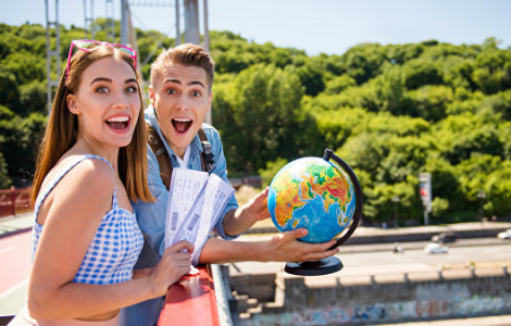 парень и девушка с авиабилетами и глобусом в руках - счастливая пара путешествует по миру
