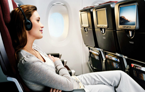 девушка в наушниках смотрит фильм в самолете во время длительного перелета